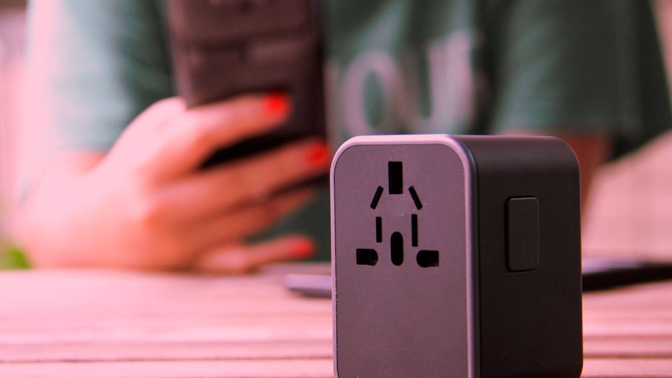Adaptador de viaje universal con puertos USB, compatible con diferentes enchufes.