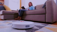 Usuario controlando aspiradora robotizada mediante aplicación en teléfono móvil