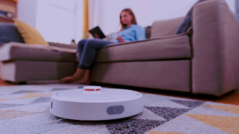 Usuario controlando aspiradora robotizada mediante aplicación en teléfono móvil